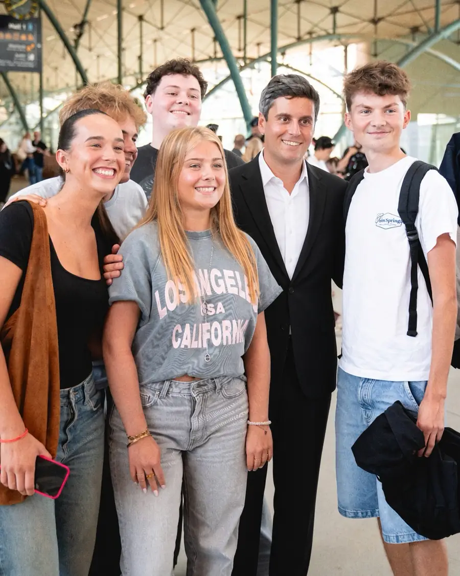 Gabriel Attal pose avec cinq jeunes dans le hall d'une gare.